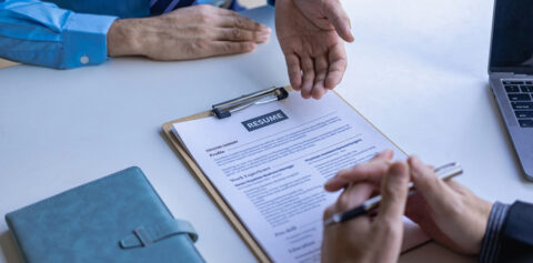a person showing their resume to another person